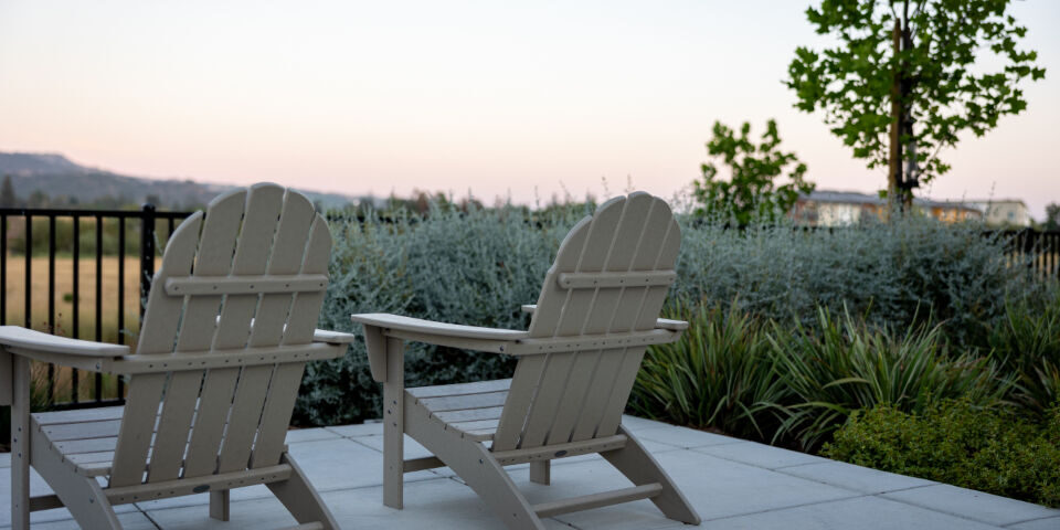 Outdoor chairs on a paved patio surrounded by garden planting Outdoor chairs on a paved patio surrounded by garden planting